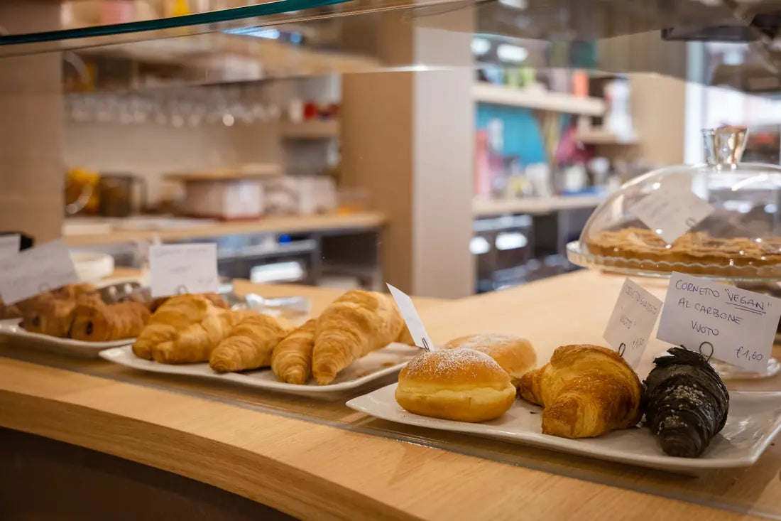 The counter with croissants and handwritten labels.